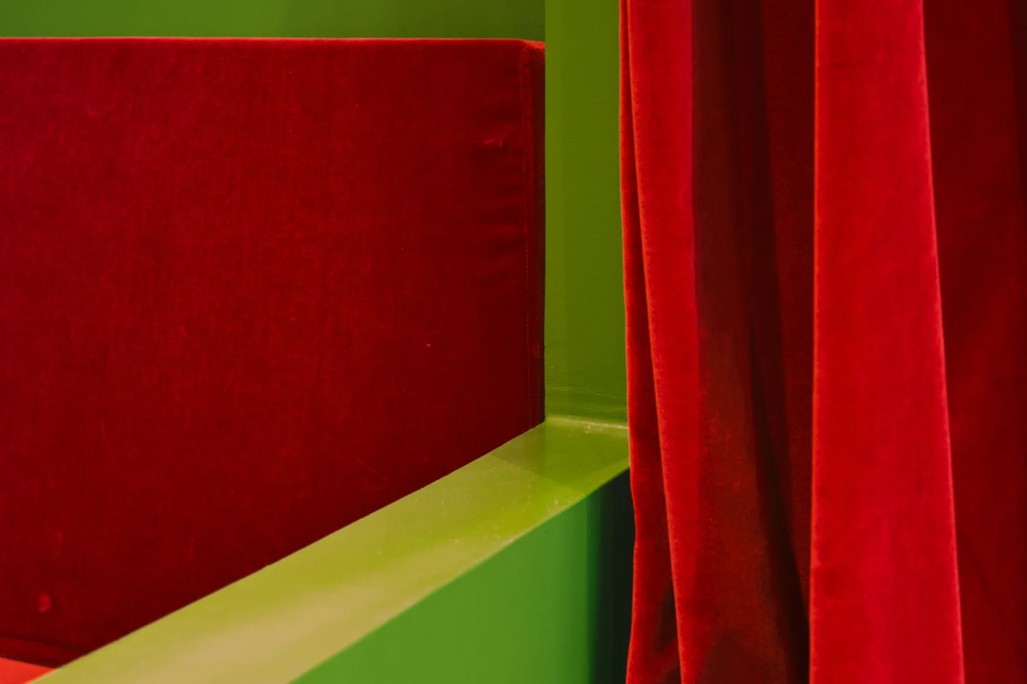La banquette de velours rouge et le rideau.