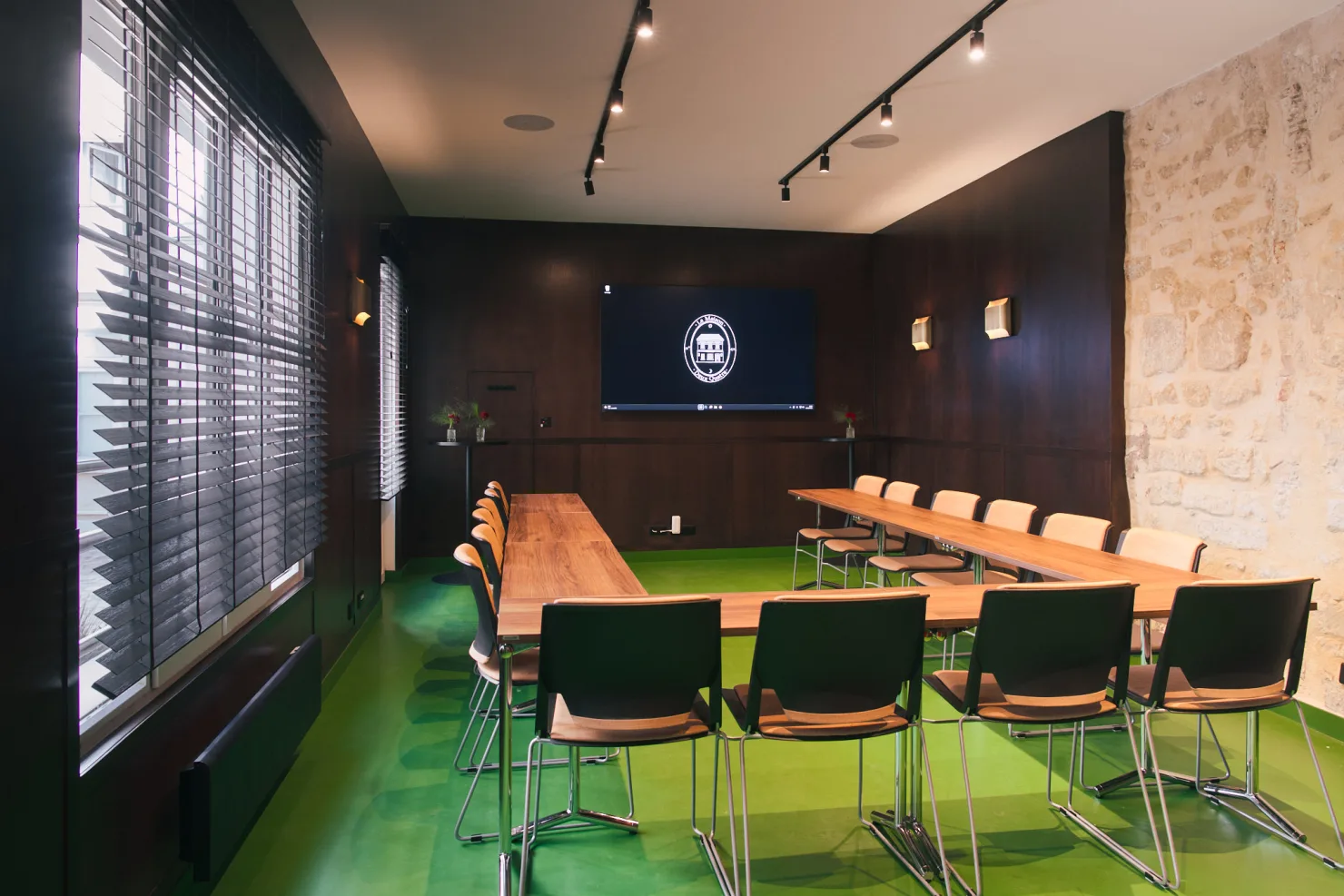 Le salon en séminaire : tables en U face à l'écran, chaises noires et chaises claires.